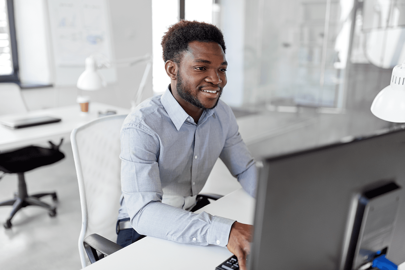 Man sitting at desk, looking at computer screen